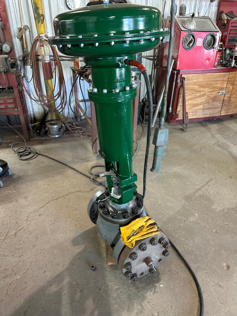 Tall green pneumatic valve assembly in the Allenco shop